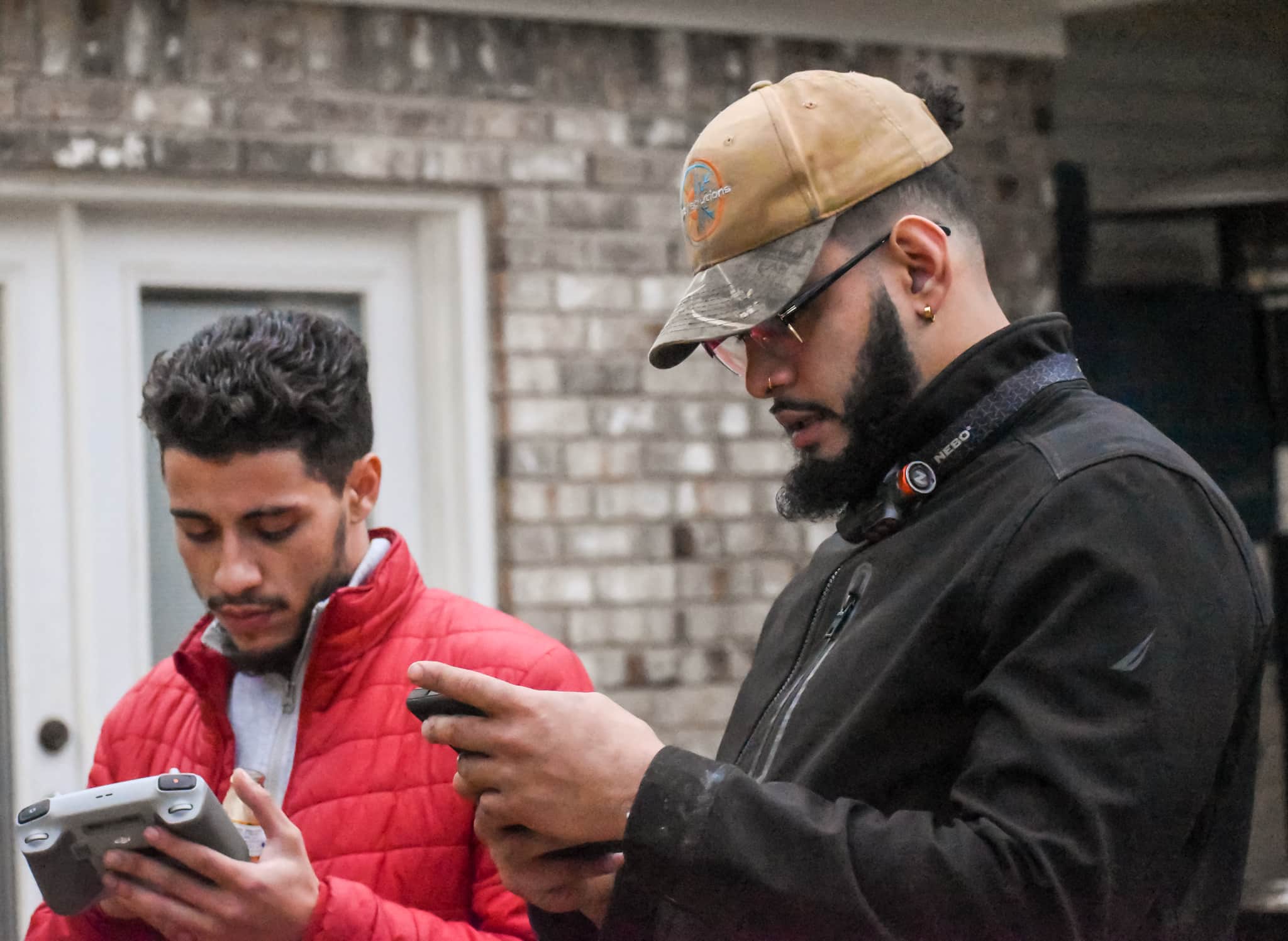 Two team members looking over equipment outside a home